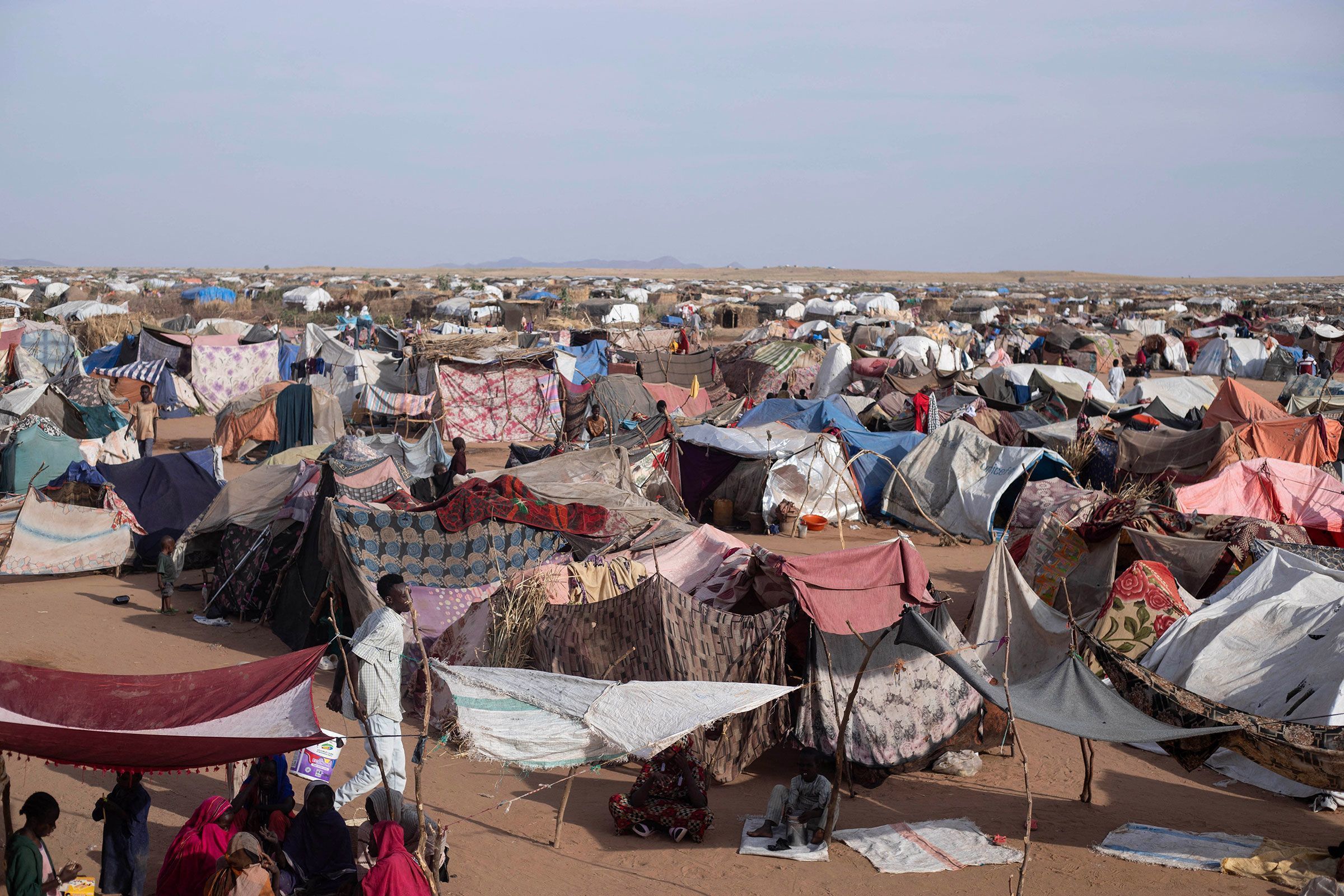 Abrigos improvisados ​​erguidos por sudaneses deslocados que fugiram das Forças de Apoio Rápido compõem o acampamento de Um Yanqur, localizado na extremidade sudoeste de Tawila, no Sudão