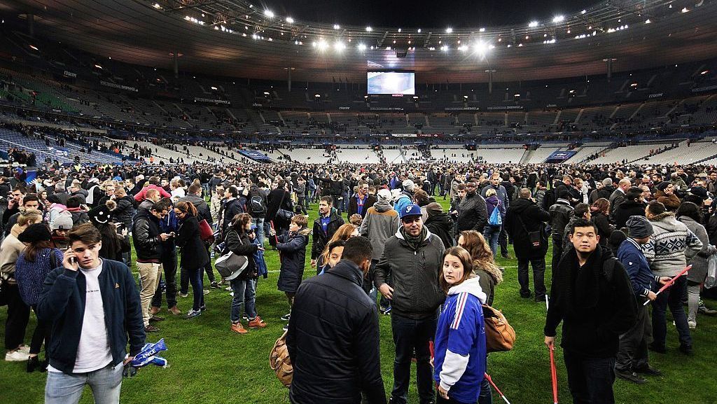 Pessoas se reúnem no gramado do Stade de France após a notícia dos atentados e ataques terroristas em Paris em 13 de novembro de 2015, em Paris, França