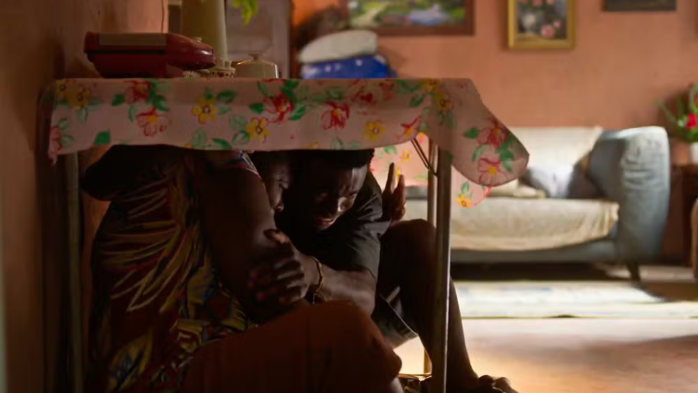 Faiska e a mãe se escondem durante tiroteio em "Dona de Mim", mas o rapaz será baleado • Divulgação/Globo