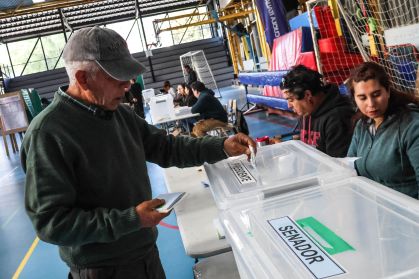 Um eleitor deposita seu voto em uma urna durante as eleições presidenciais chilenas de 2025, em Valparaíso, 16 de novembro de 2025.