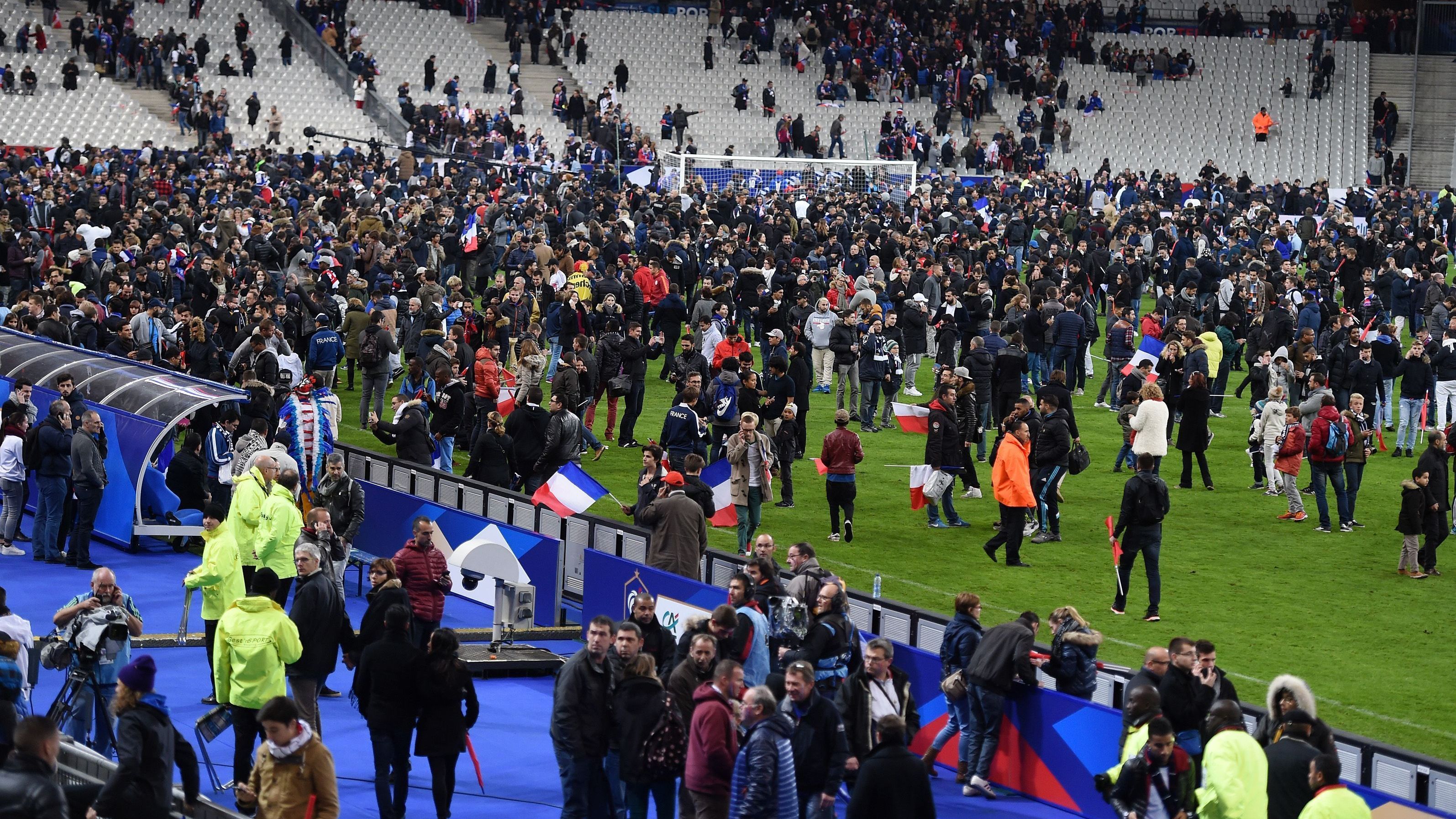 Torcedores no gramado do Stade France após atentado no estádio, em 2015
