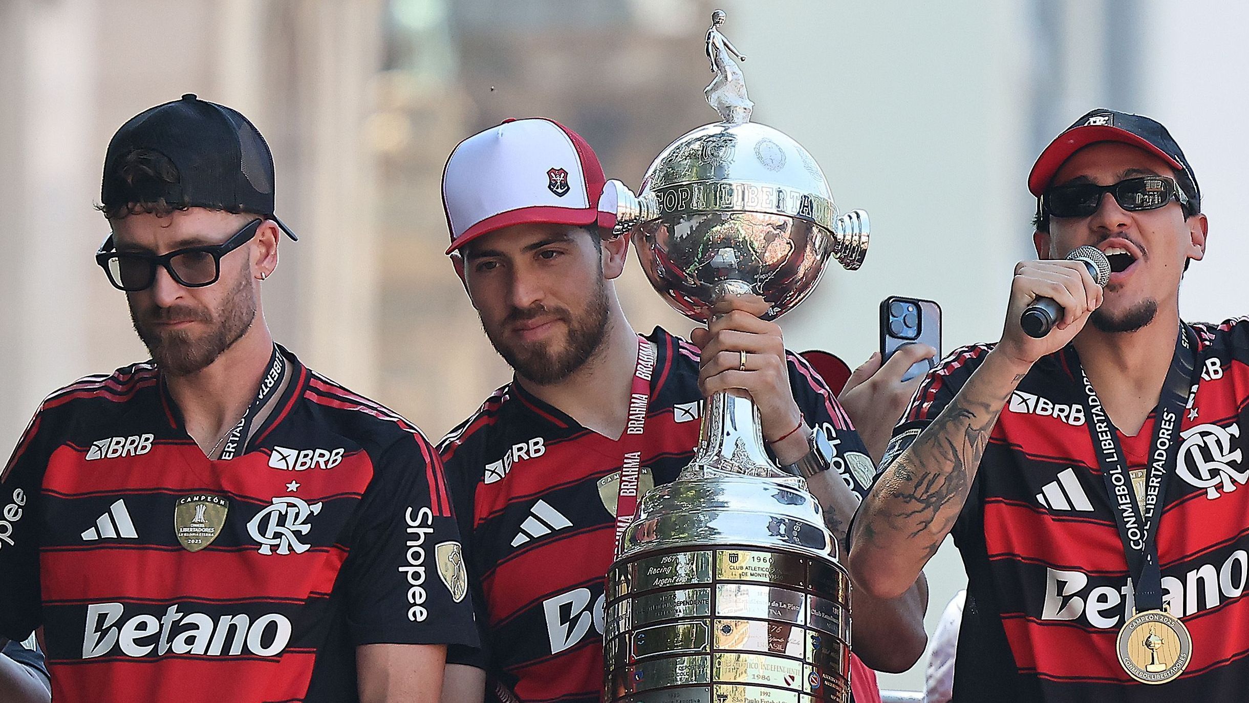 Jogadores do Flamengo seguram a taça da Libertadores durante a festa do título nas ruas do Rio