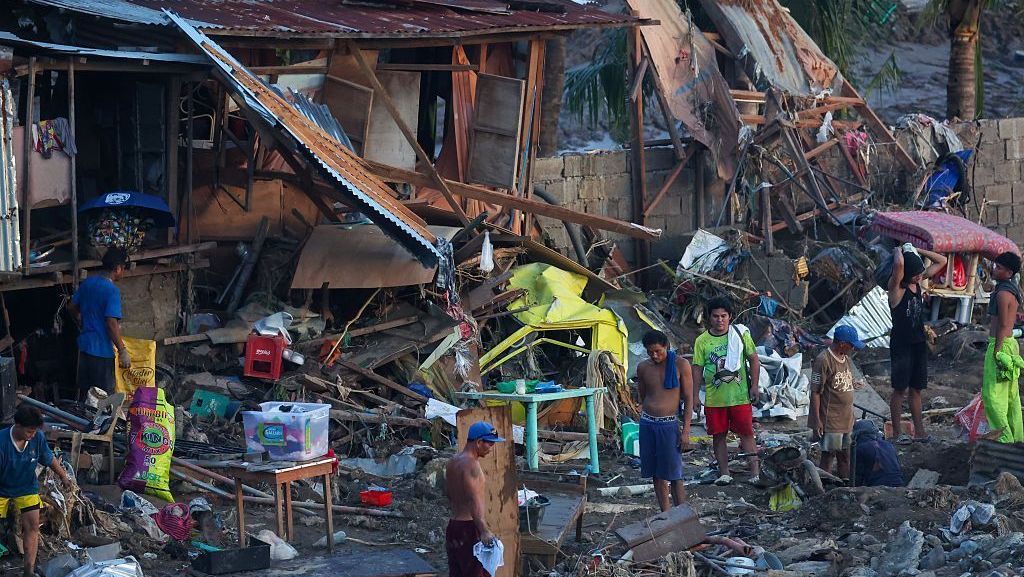 Moradores avaliam o que pode ser recuperado dos escombros de casas destruídas após passagem do tufão Kalmaegi em Biasong, província de Cebu, Filipinas
