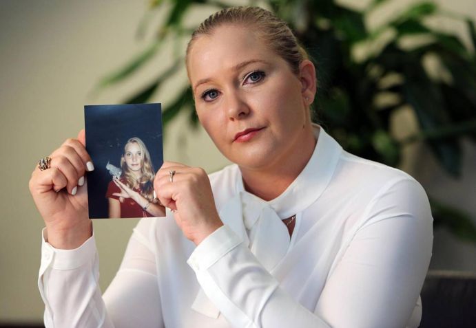 Virginia Giuffre, com uma foto de si mesma na adolescência, época em que afirma ter sido abusada por Jeffrey Epstein, Ghislaine Maxwell e o Príncipe Andrew • Emily Michot/Miami Herald/Tribune News Service via Getty Images