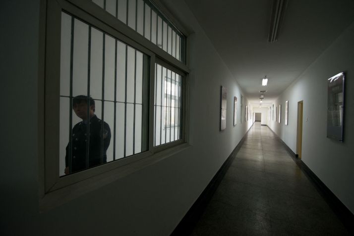Um guarda observa pela janela de um corredor dentro do Centro de Detenção nº 1 durante uma visita guiada do governo em Pequim, em 25 de outubro de 2012 • Ed Jones/AFP/Getty Images via CNN Newsource