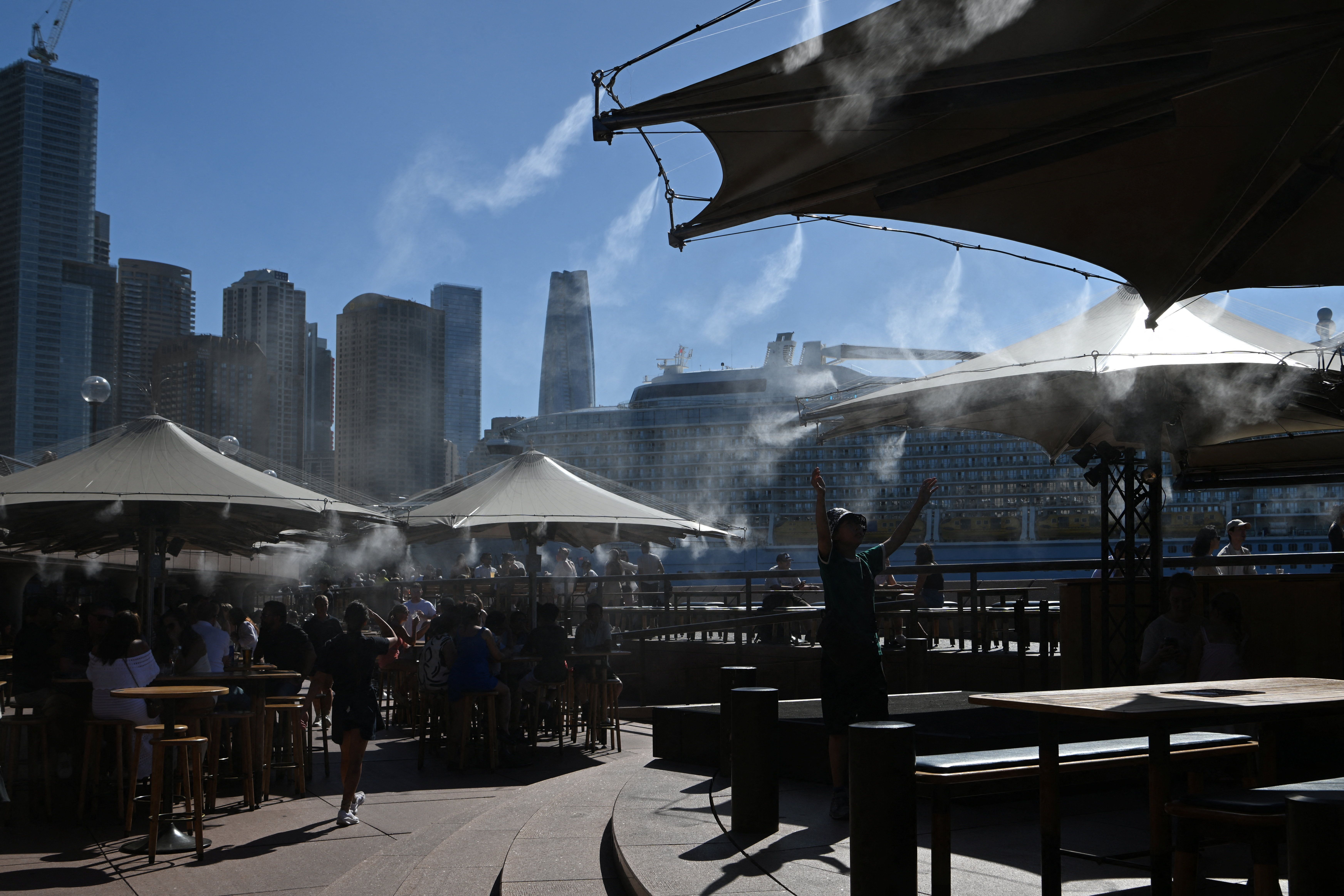 Pessoas se refrescam sob névoa de água durante calor intenso em Sydney, Austrália
