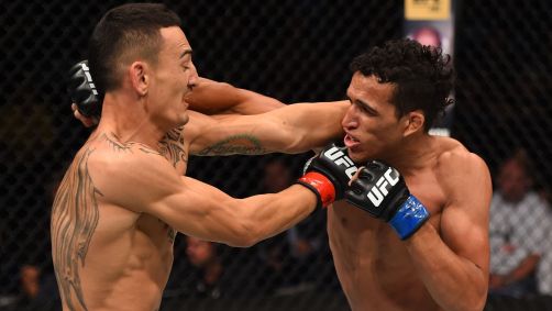 Charles "do Bronx" Oliveira acerta um soco em Max Holloway durante a luta na categoria peso-pena no evento do UFC realizado no SaskTel Centre em 23 de agosto de 2015 em Saskatoon, Saskatchewan, Canadá