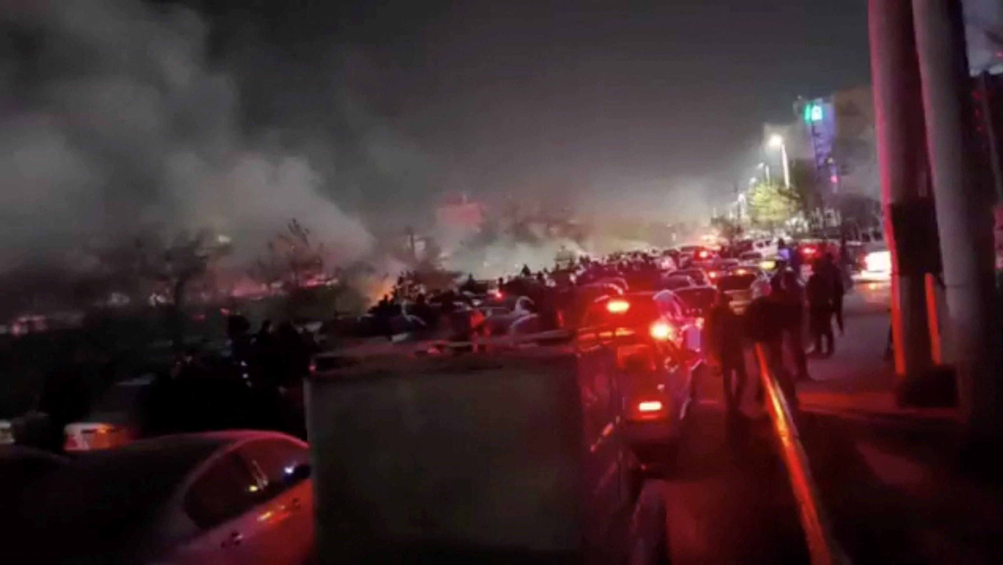 Fumaça sobe enquanto manifestantes protestam contra o governo do Irã em Mashhad, no Irã