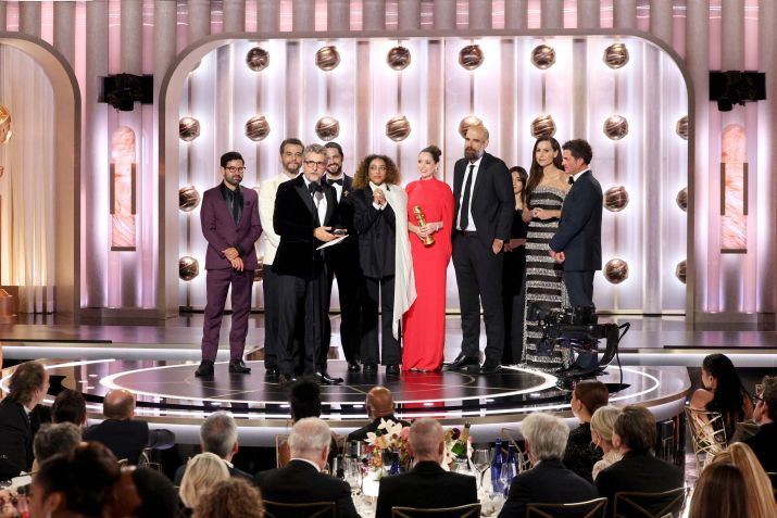 Elenco de "O Agente Secreto" recebendo o prêmio de Melhor Filme de Língua Não Inglesa no Globo de Ouro; Steven Spielberg estava na plateia • Getty Images