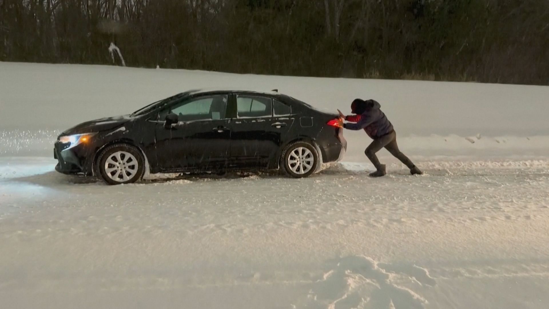 Homem empurra veículo na neve nos Estados Unidos
