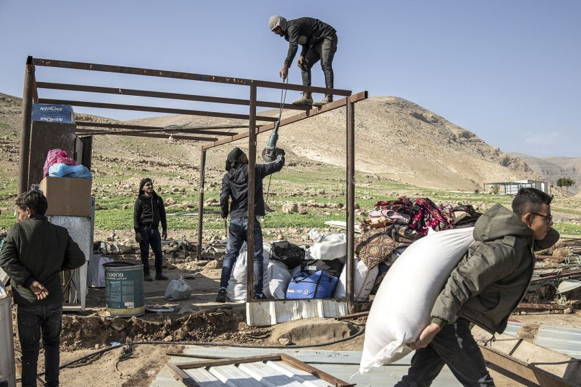 Men help dismantle a house as a Bedouin family packs up their belongings and leaves their home after months of harassment from a nearby illegal Israeli settlement, in Ras Ein al-Auja, near Jericho in the Israeli-occupied West Bank, on January 8, 2026 • John Wessels/AFP/Getty Images via CNN Newsource