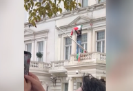 Manifestante estende bandeira pré-revolução em embaixada do Irã em Londres