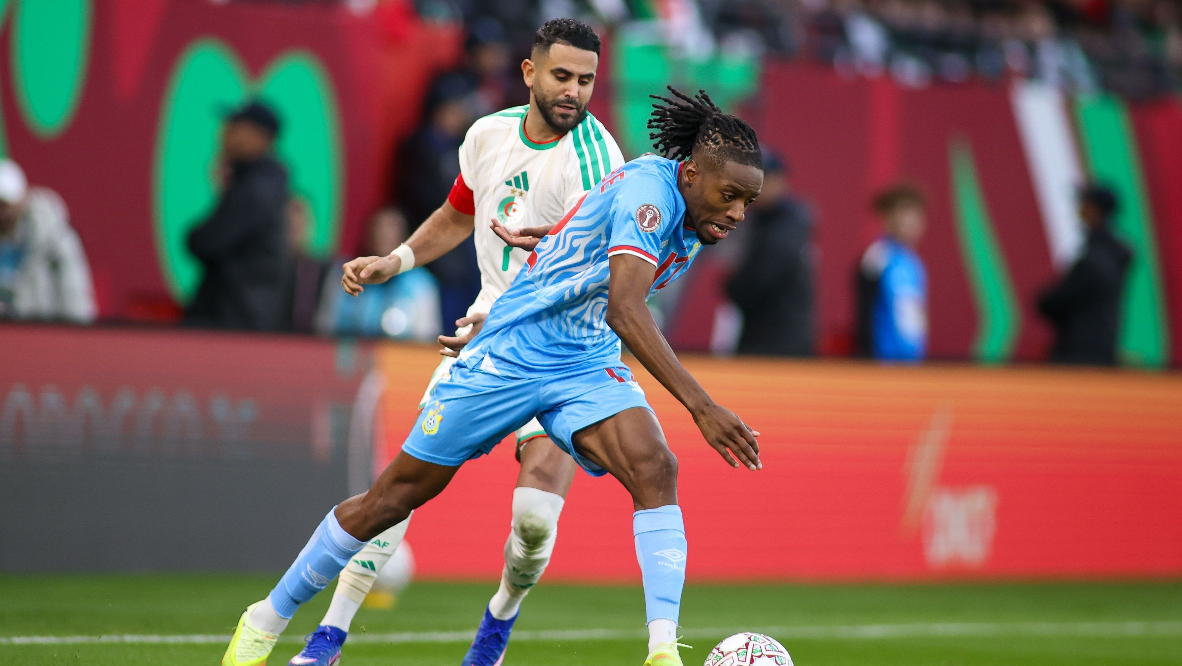 Joris Kayembe e Mahrez disputam bola na partida entre Argélia e RD Congo • Foto: Torbjorn Tande/DeFodi Images/DeFodi via Getty Images