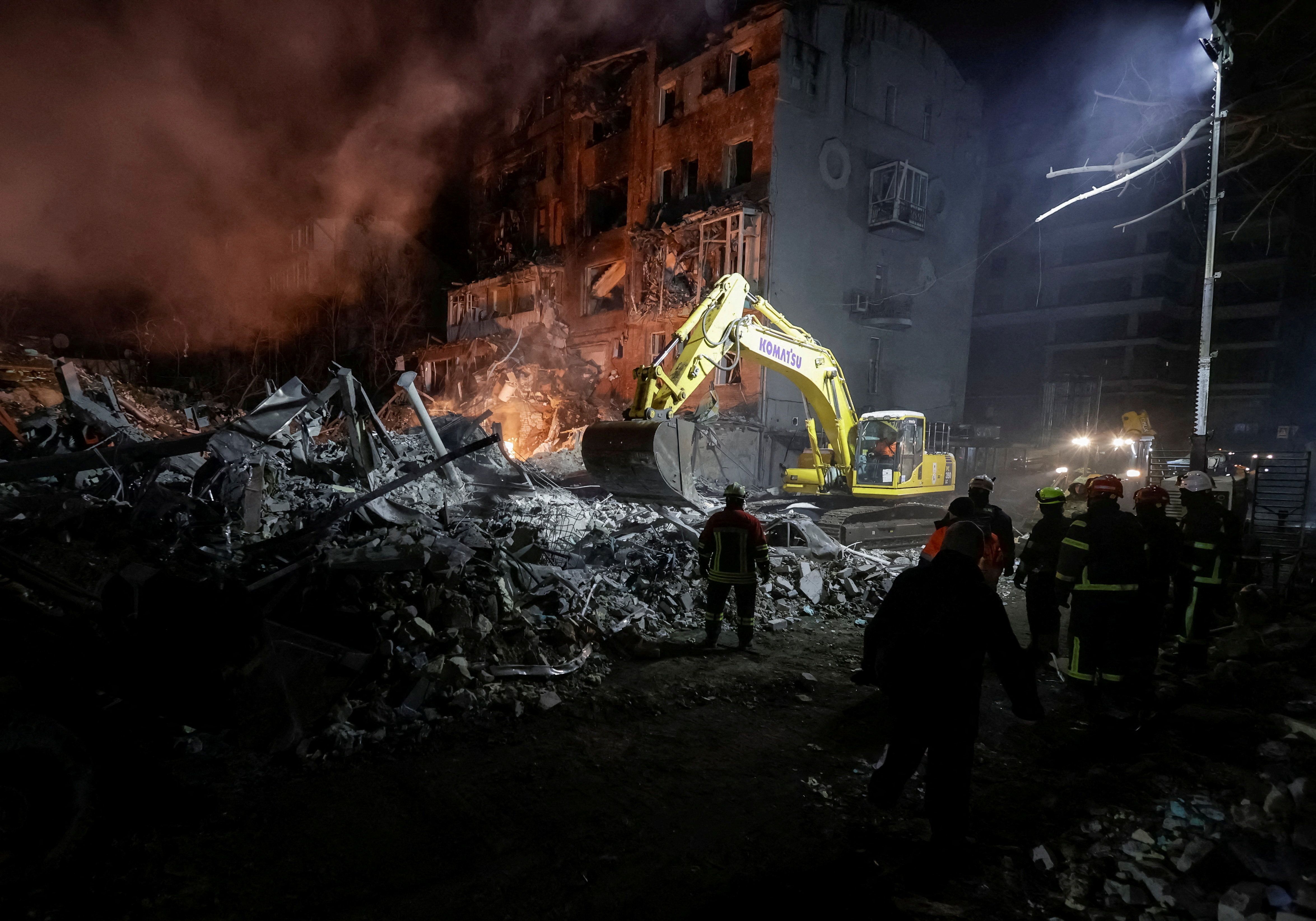 Equipes de resgate trabalham no local de um prédio de apartamentos atingido por um ataque aéreo russo, em Kharkiv