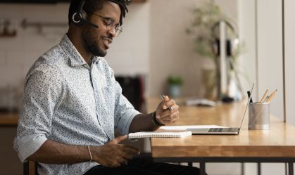 Smiling young African American man studying online.