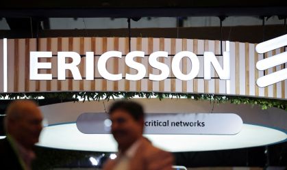 Participantes conversando perto do estande da Ericsson na India Mobile Congress 2025, em Nova Délhi, Índia