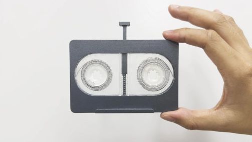 mão-segurando-fita-cassete-de-DNA