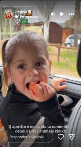 Maria Flor come cenoura que iria oferecer aos animais durante o safari • Instagram/Virginia