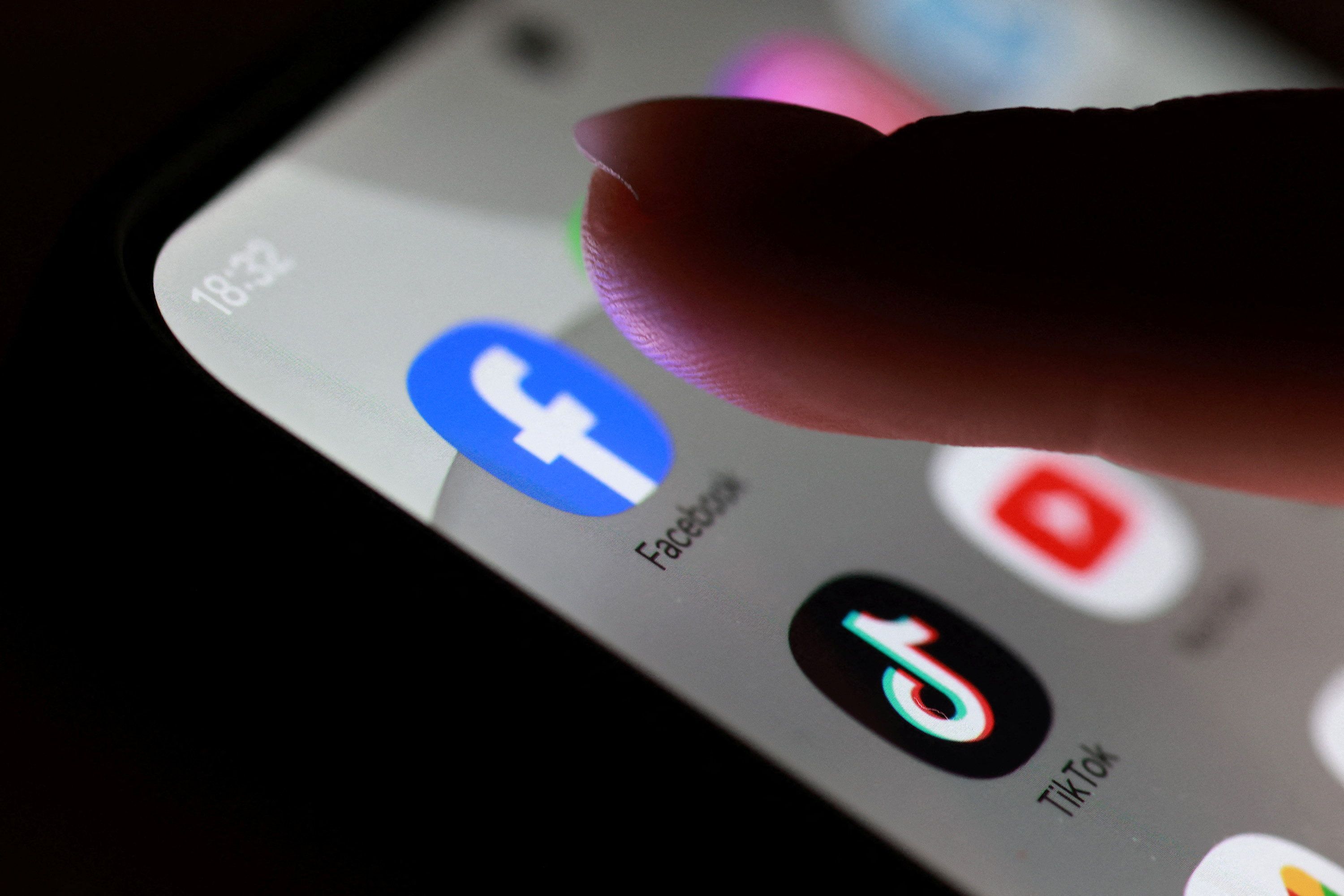 Ícones do Facebook, do TikTok e do YouTube em tela de celular