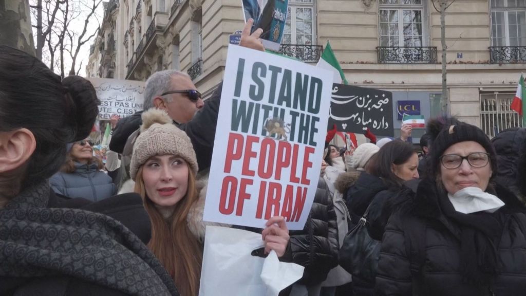 Manifestante segurando um cartaz com os dizeres " Eu estou com o povo do Irã"