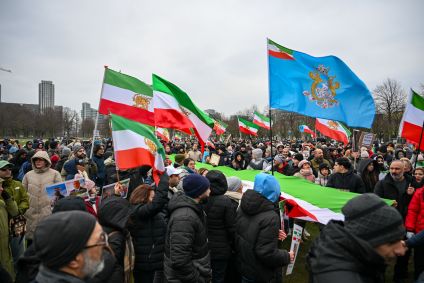 Manifestantes se reúnem em Haia, na Holanda, em 10 de janeiro de 2026, para demonstrar apoio aos protestos no Irã. A polícia monitora a área enquanto participantes e contramanifestantes compartilham as ruas, mantendo a ordem durante o evento