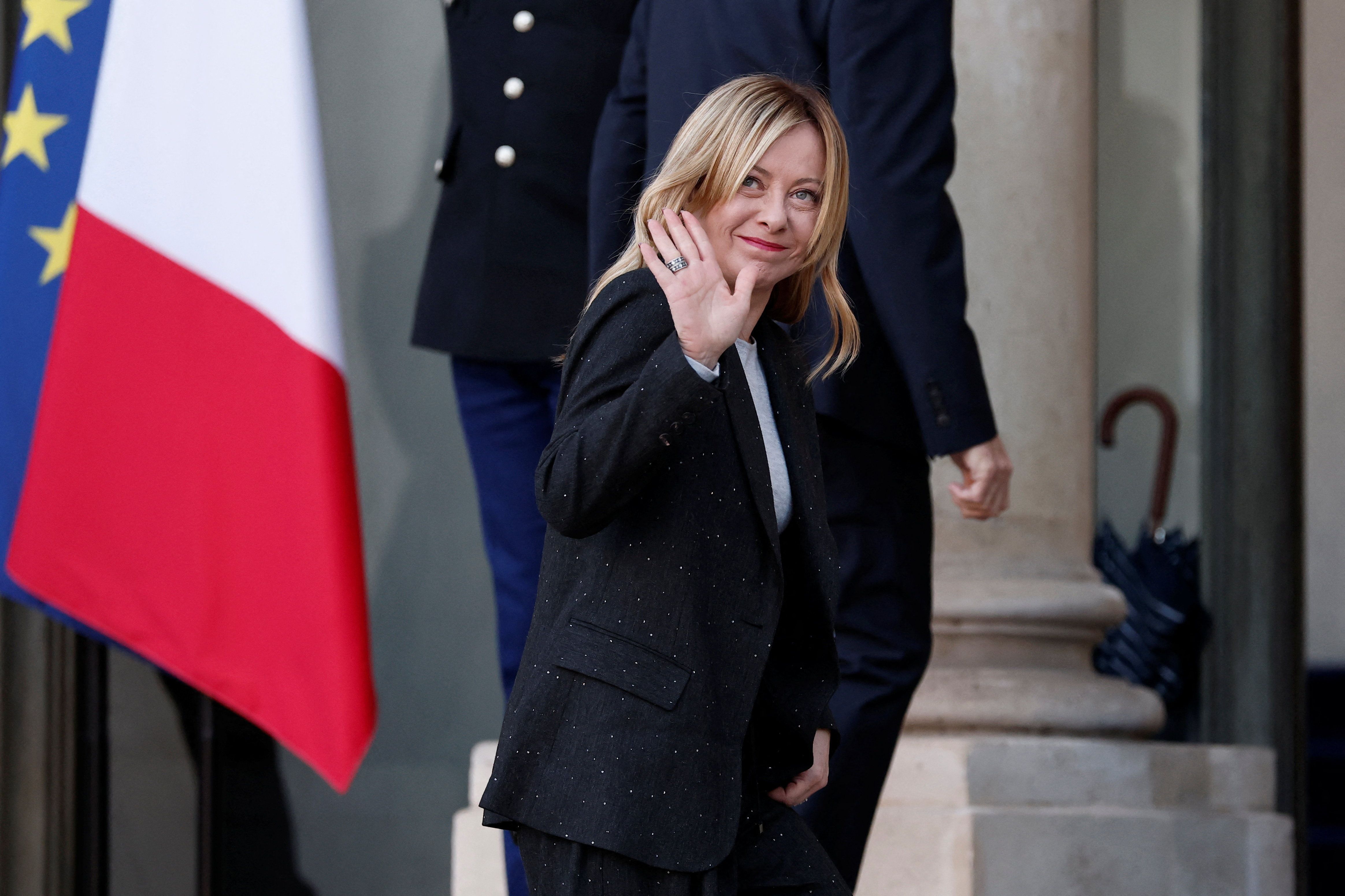 Primeira-ministra da Itália, Giorgia Meloni, acena ao chegar para reunião no Palácio do Eliseu, em Paris.