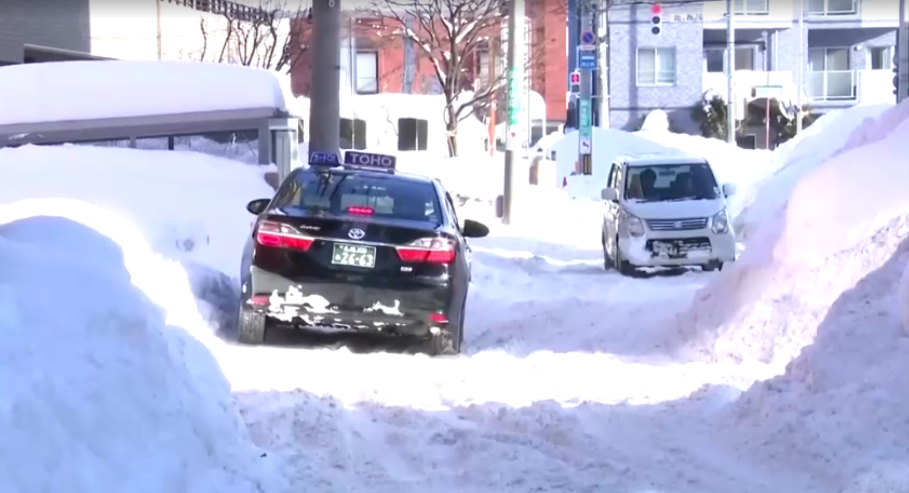 Carros tentam passar pelas ruas cheias de neve em Aomori, no Japão