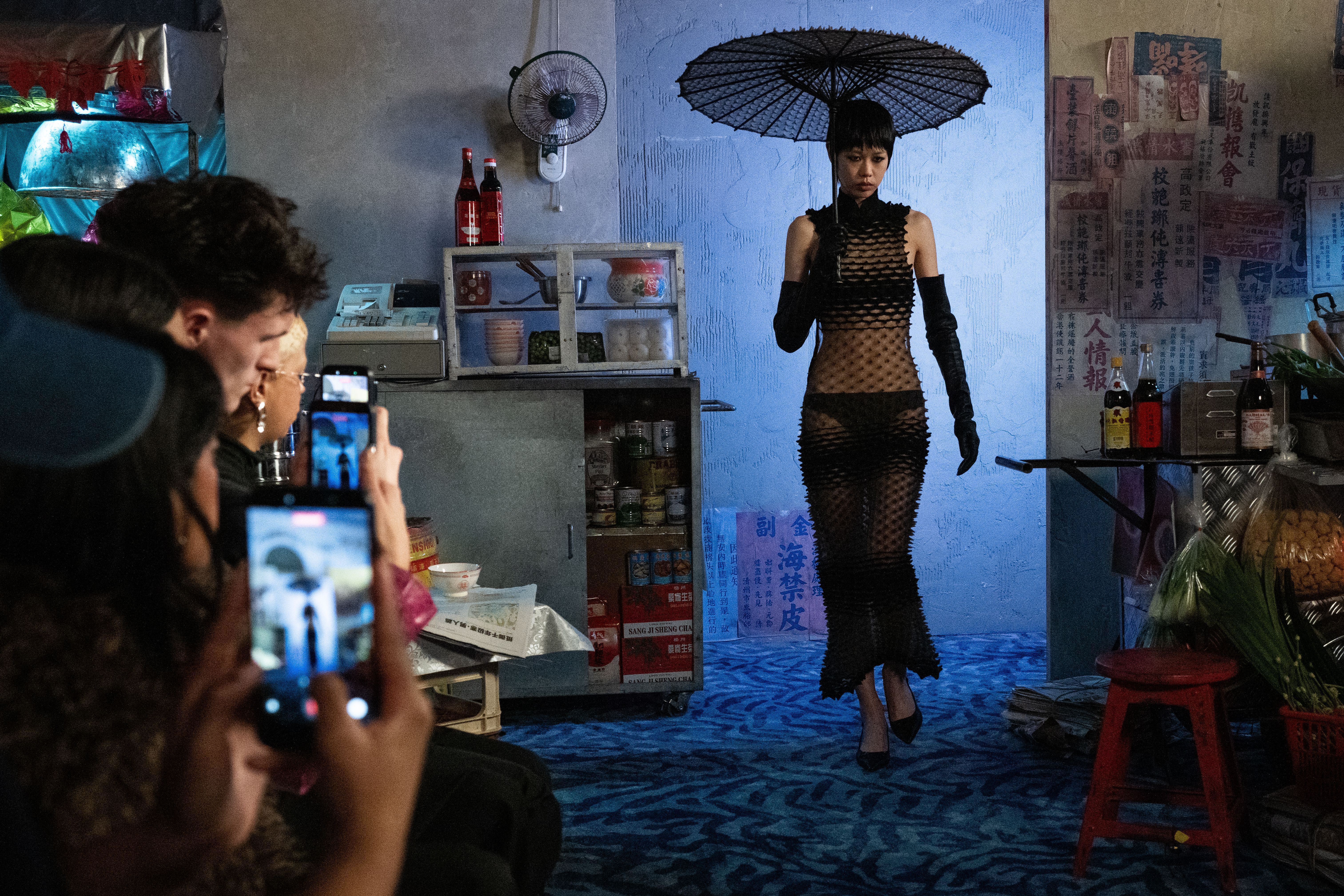 Chet Lo, que normalmente realiza seus desfiles em um espaço para estilistas emergentes cedido pelo BFC, desta vez apresentou seu desfile no hotel Mandarin Oriental. Lá, ele explorou suas raízes ao transformar o salão de baile em um mercado noturno de Hong Kong • Eamonn M. McCormack/Getty Images