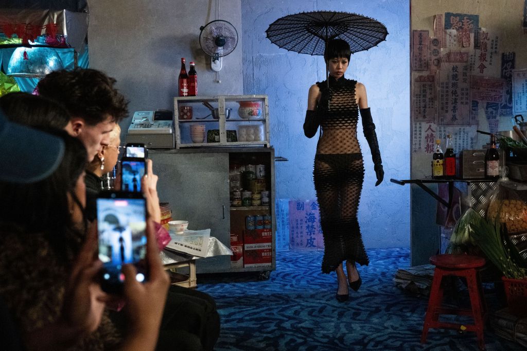 Chet Lo, que normalmente realiza seus desfiles em um espaço para estilistas emergentes cedido pelo BFC, desta vez apresentou seu desfile no hotel Mandarin Oriental. Lá, ele explorou suas raízes ao transformar o salão de baile em um mercado noturno de Hong Kong