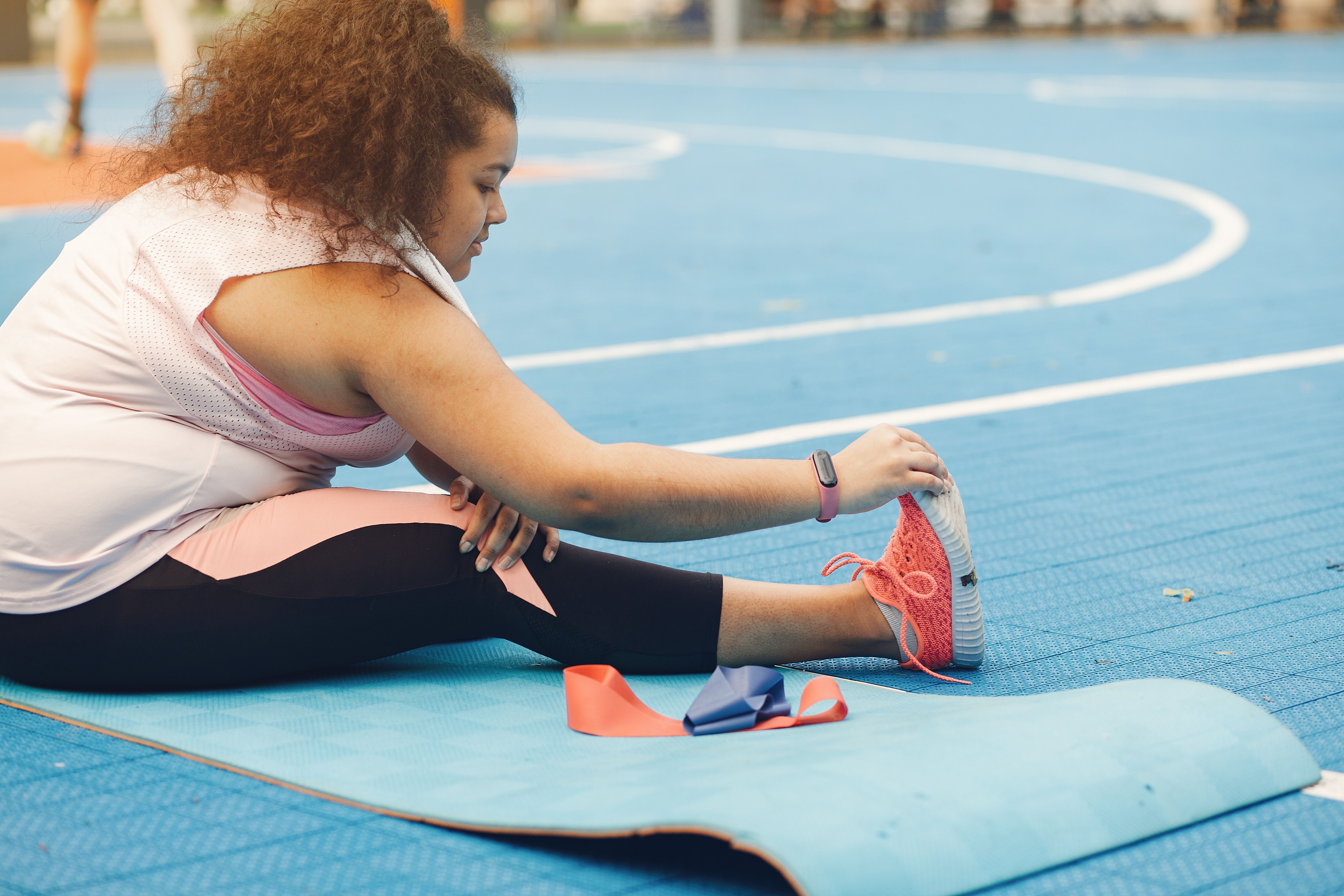 Mulher se alonga em uma pista de corrida