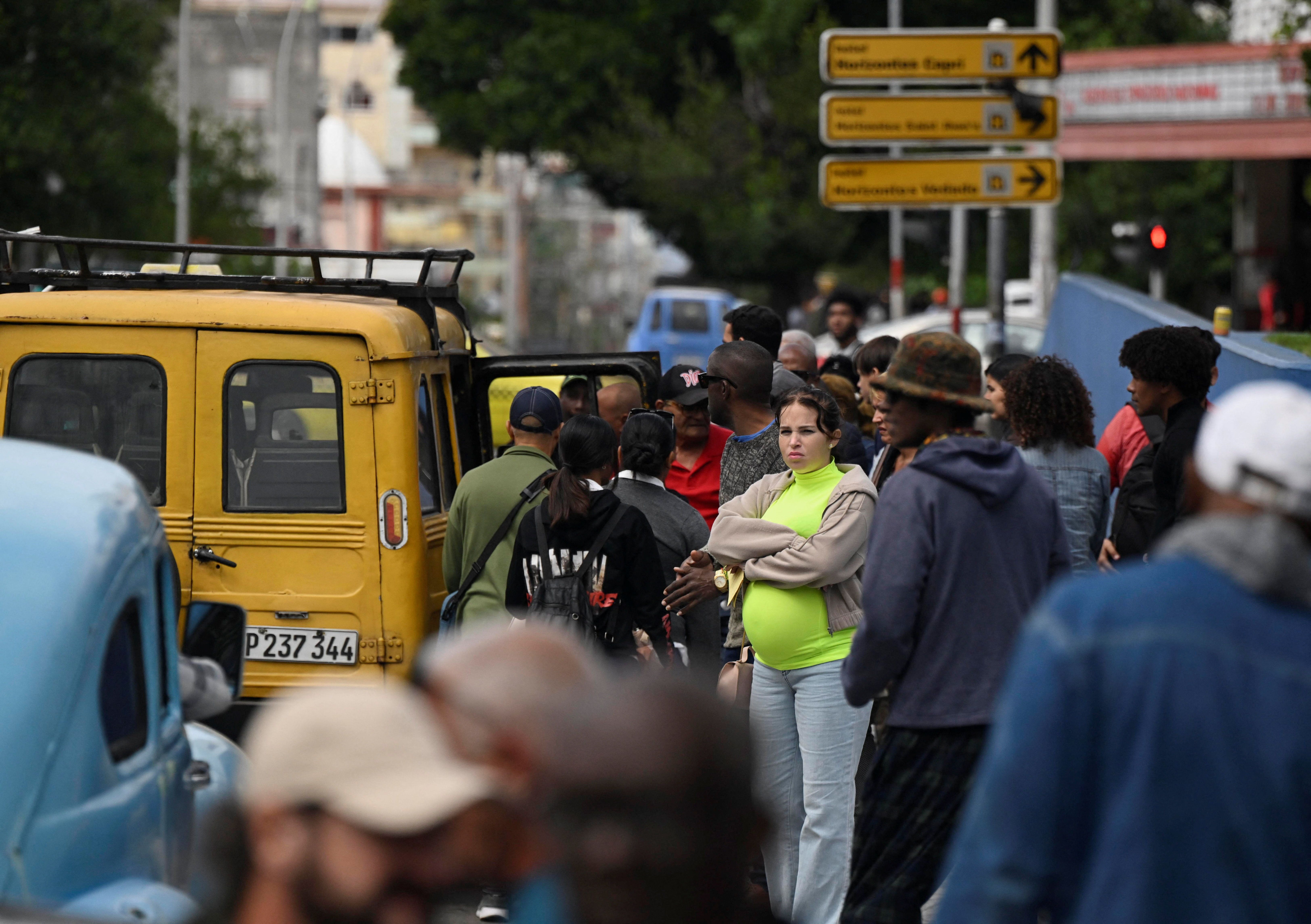 Pessoas aguardam por transporte em Havana