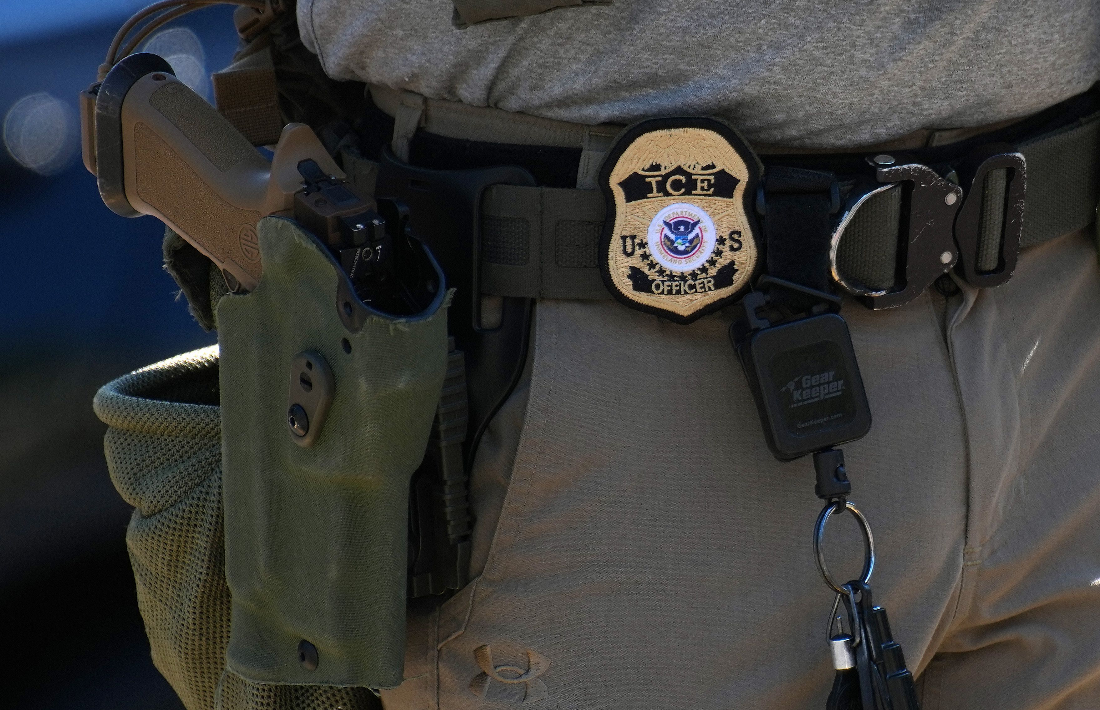 Distintivo e arma de um agente do ICE, a polícia de imigração dos EUA, são vistos durante uma blitz na Avenida Georgia, em 30 de agosto de 2025, em Washington, DC.