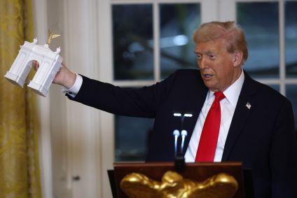 O presidente dos EUA, Donald Trump, segura um modelo de arco enquanto faz comentários durante um jantar de arrecadação de fundos no Salão Leste da Casa Branca em 15 de outubro de 2025 em Washington, DC