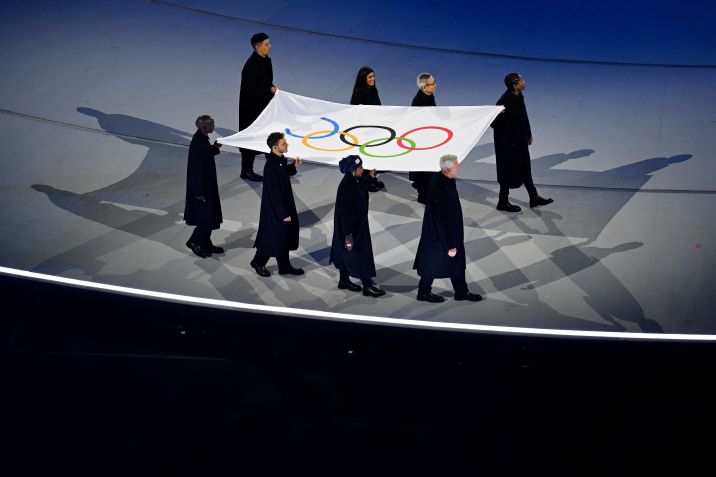 Tadatoshi Akiba, Rebeca Andrade, Maryam Bukar Hassan, Nicolo Govoni, Filippo Grandi, Eliud Kipchoge, Cindy Ngamba e Pita Taufatofua carregaram a bandeira • Photo by Matthias Hangst/Getty Images