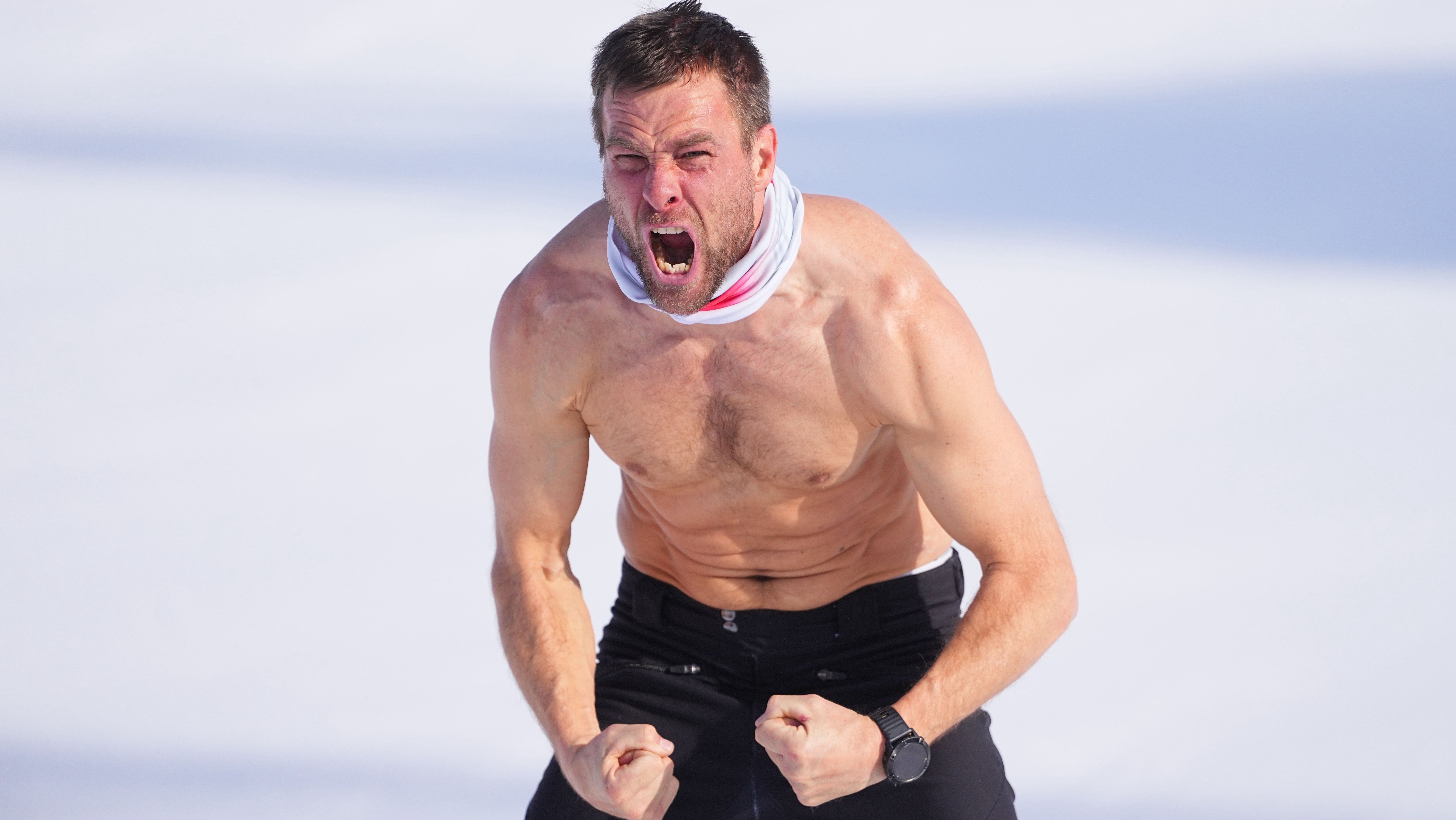 Snowboarder Benjamin Karl tira a camisa para comemorar o ouro olímpico no slalom gigante paralelo dos Jogos de Inverno Milão-Cortina