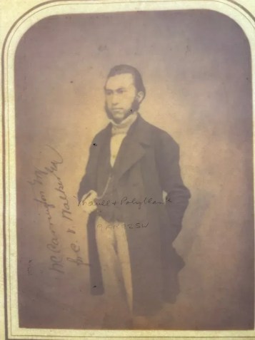 Colocada com a face para baixo sobre uma caixa de luz, a foto revela uma inscrição • Sociedade Real de Astronomia