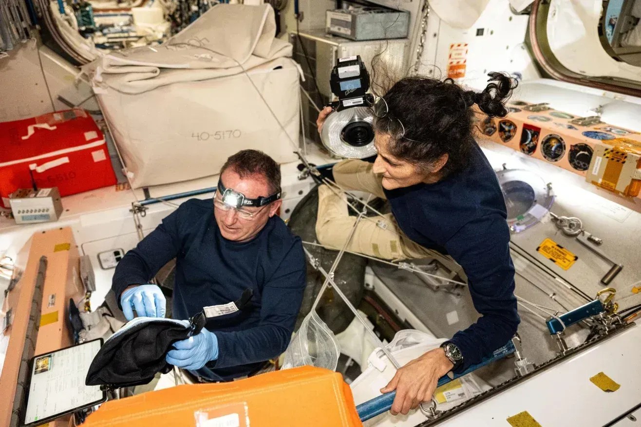 Os astronautas da NASA Butch Wilmore (à esquerda) e Suni Williams, que atuaram como tripulantes no voo de teste da Boeing Starliner, inspecionam os equipamentos de segurança a bordo da Estação Espacial Internacional • Nasa