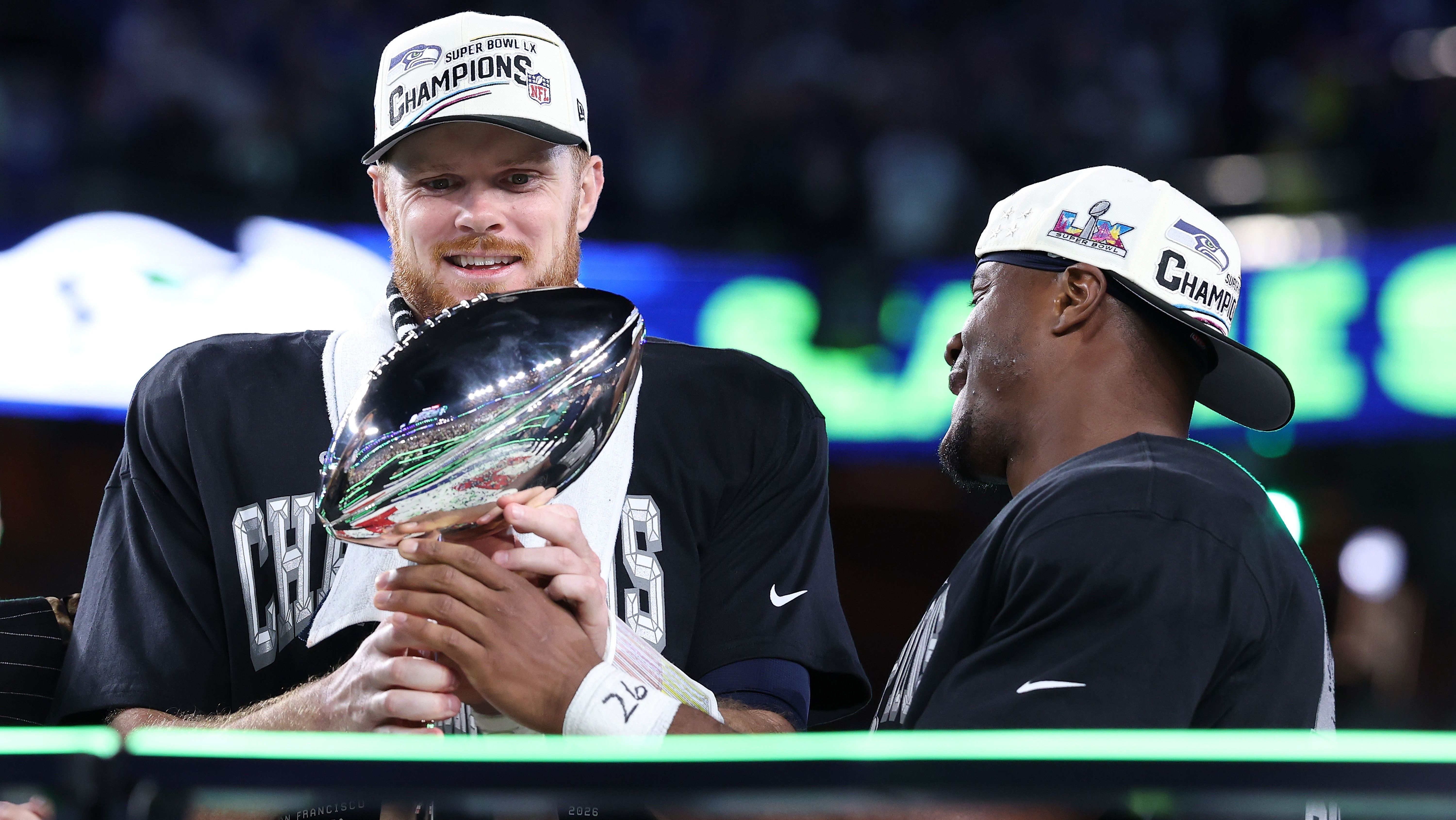 Sam Darnold e Kenneth Walker III, do Seattle Seahawks, com o troféu de campeões do Super Bowl LX