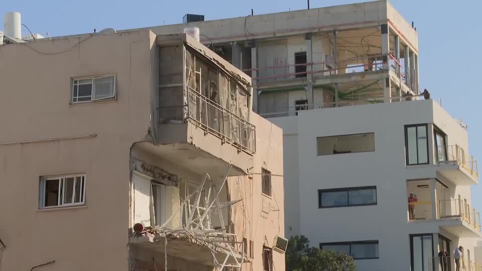 Israeli emergency response unit inspecting scene of damage in Tel Aviv from Iranian strike