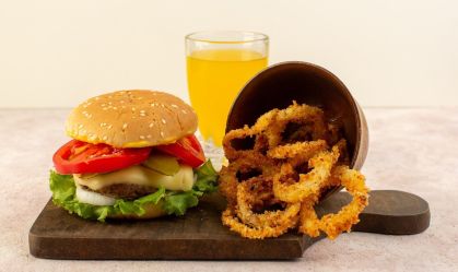 Visão-frontal-de-um-hambúrguer-de-carne-com-molho-de-queijo-salada-e-asas-de-frango