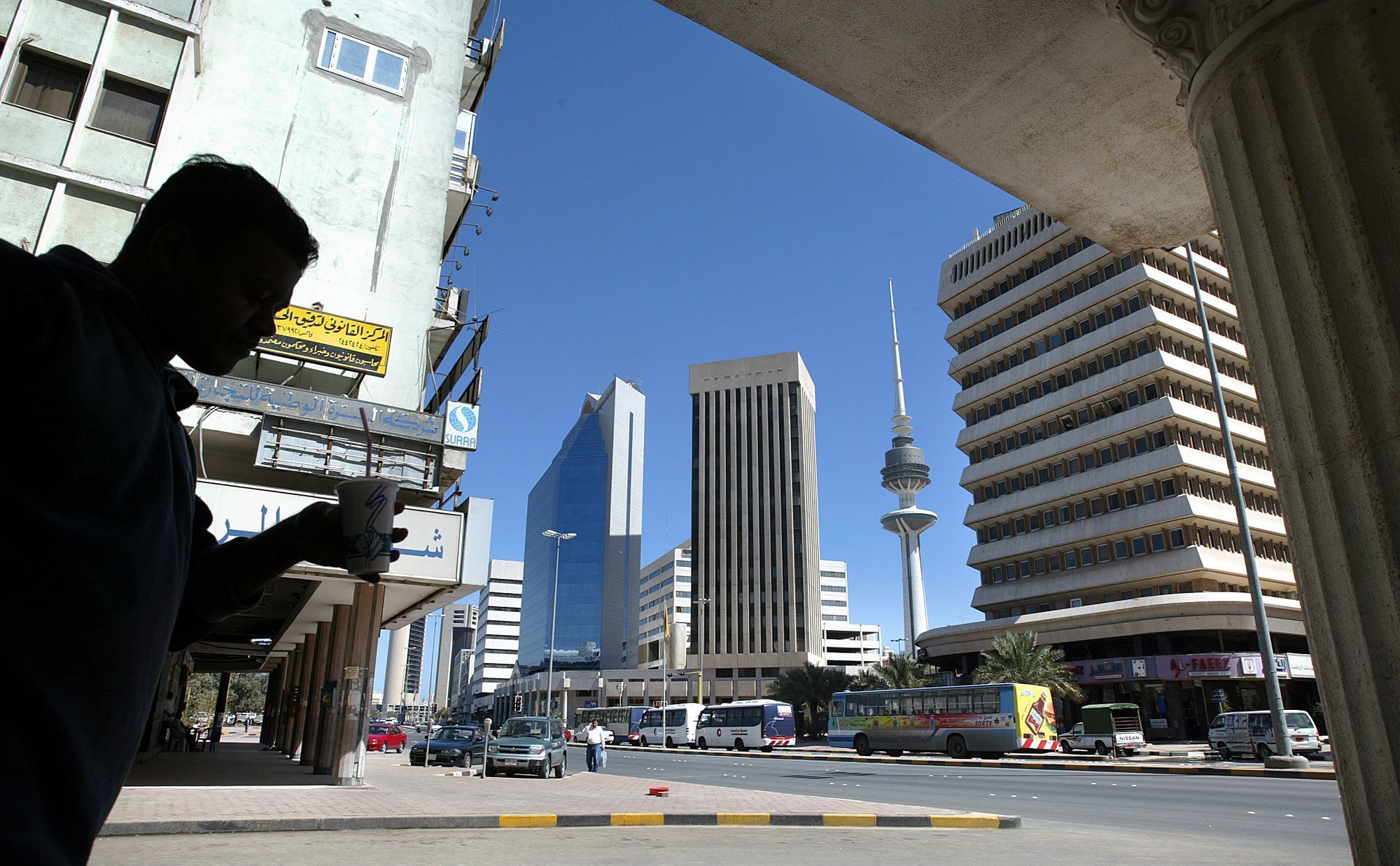 Centro da cidade do Kuwait como é atualmente. Parte da paisagem urbana inclui o 5º edifício mais alto do mundo. A Torre da Libertação começou a ser construída em 1987 e foi interrompida durante a invasão iraquiana. Originalmente chamada de Torre Tahreer, o nome foi alterado após a libertação do Iraque em 1991