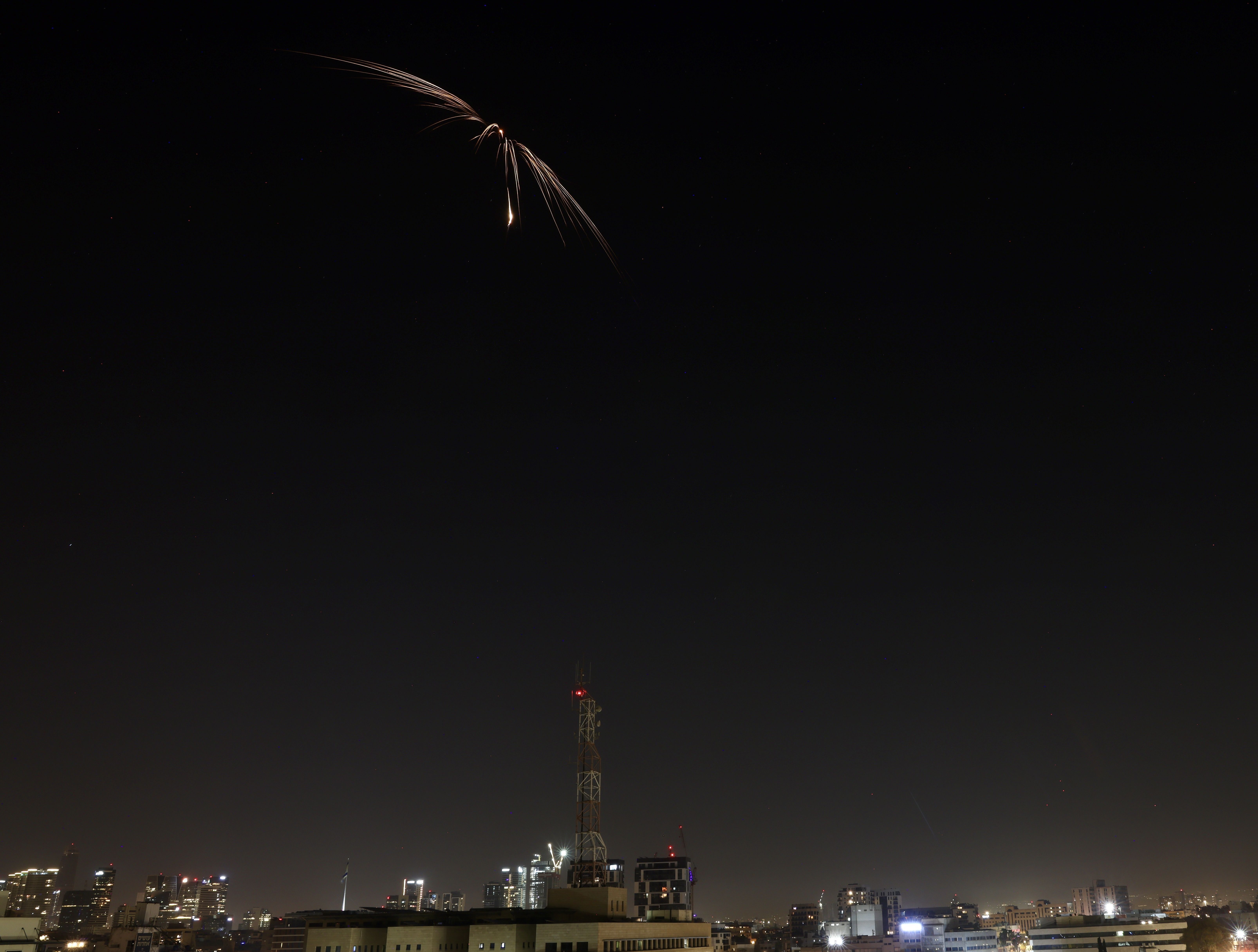 Mísseis lançados do Irã em direção a Israel aparecem no céu sobre Tel Aviv durante um ataque na noite desta terça-feira (17), horário de Brasília