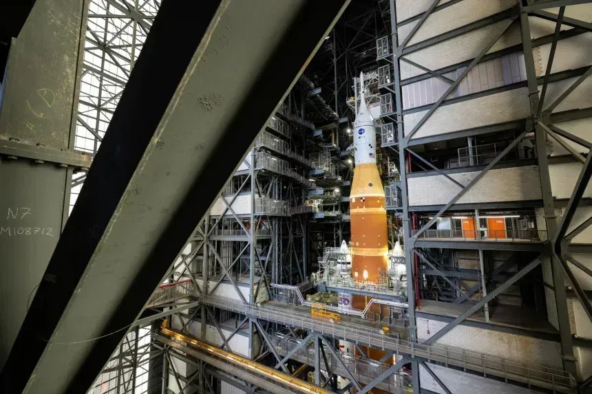 O foguete Artemis II do Sistema de Lançamento Espacial da NASA e a espaçonave Orion, fixados à plataforma de lançamento móvel, aparecem dentro do Edifício de Montagem de Veículos em janeiro, no Centro Espacial Kennedy. • Keegan Barber/AP