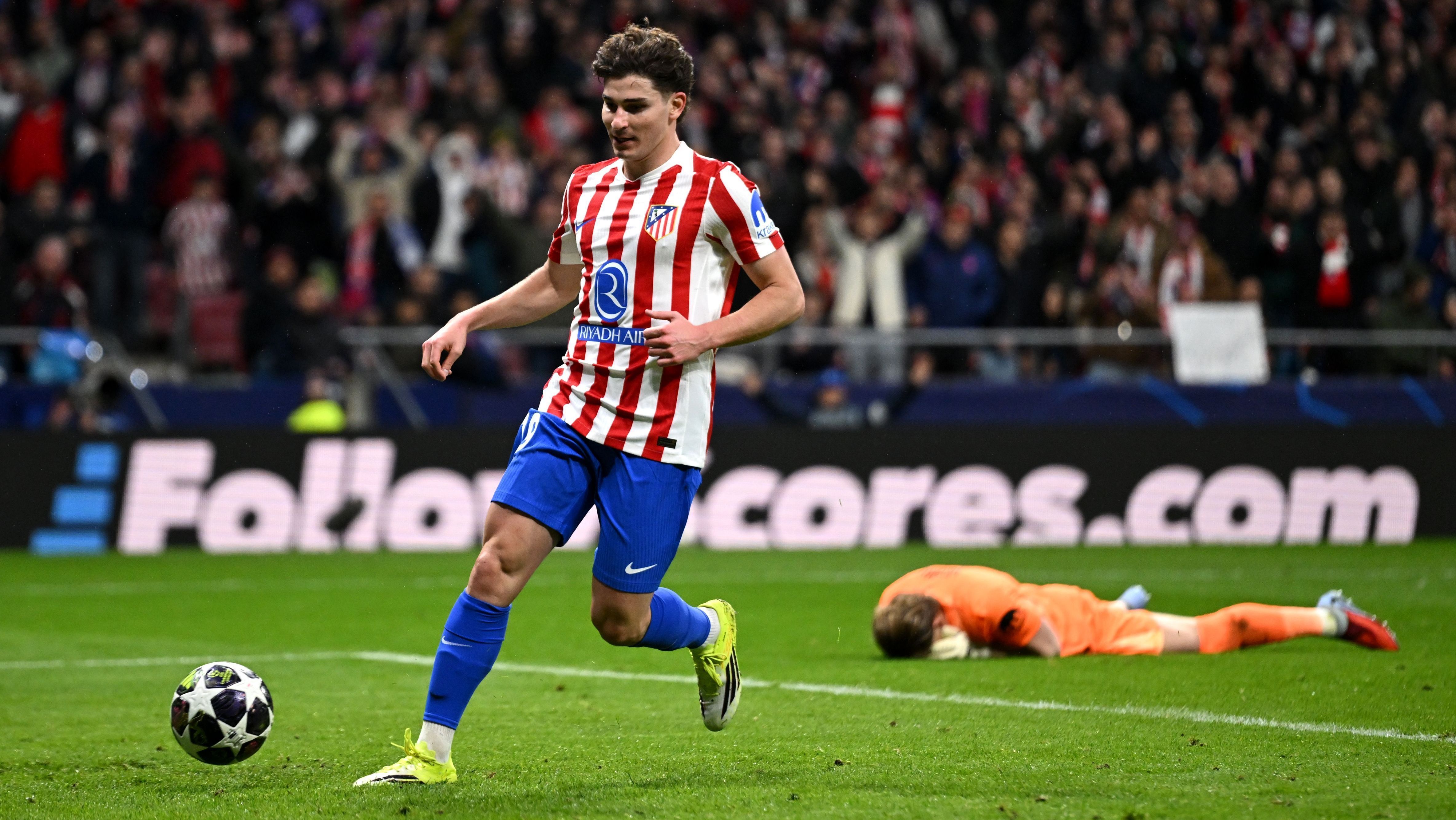 Julián Álvarez, do Atlético de Madrid, finaliza para o gol vazio, enquanto o goleiro Antonin Kinsky, do Tottenham, lamenta a falha deitado no gramado; o Atleti venceu a partida de goleada