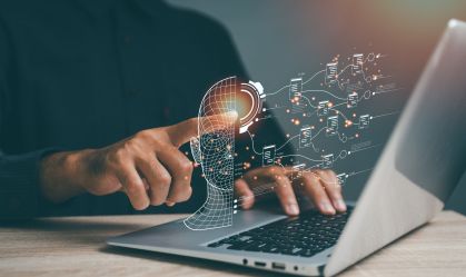 A person is using a laptop to draw a brain