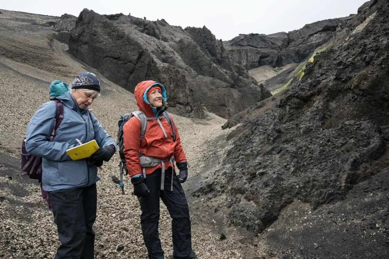 Cindy Evans (à esquerda), líder do treinamento em geologia do programa Artemis da NASA, e a astronauta da Artemis II, Christina Koch, estudam formações geológicas semelhantes às da Lua na Islândia • Robert Markowitz/Nasa-JSC