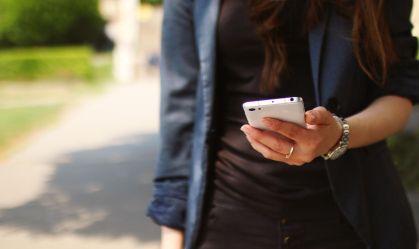 mulher-usando-smartphone-na-rua-segurando-celular-em-ambiente-externo-com-foco-em-tecnologia-movel
