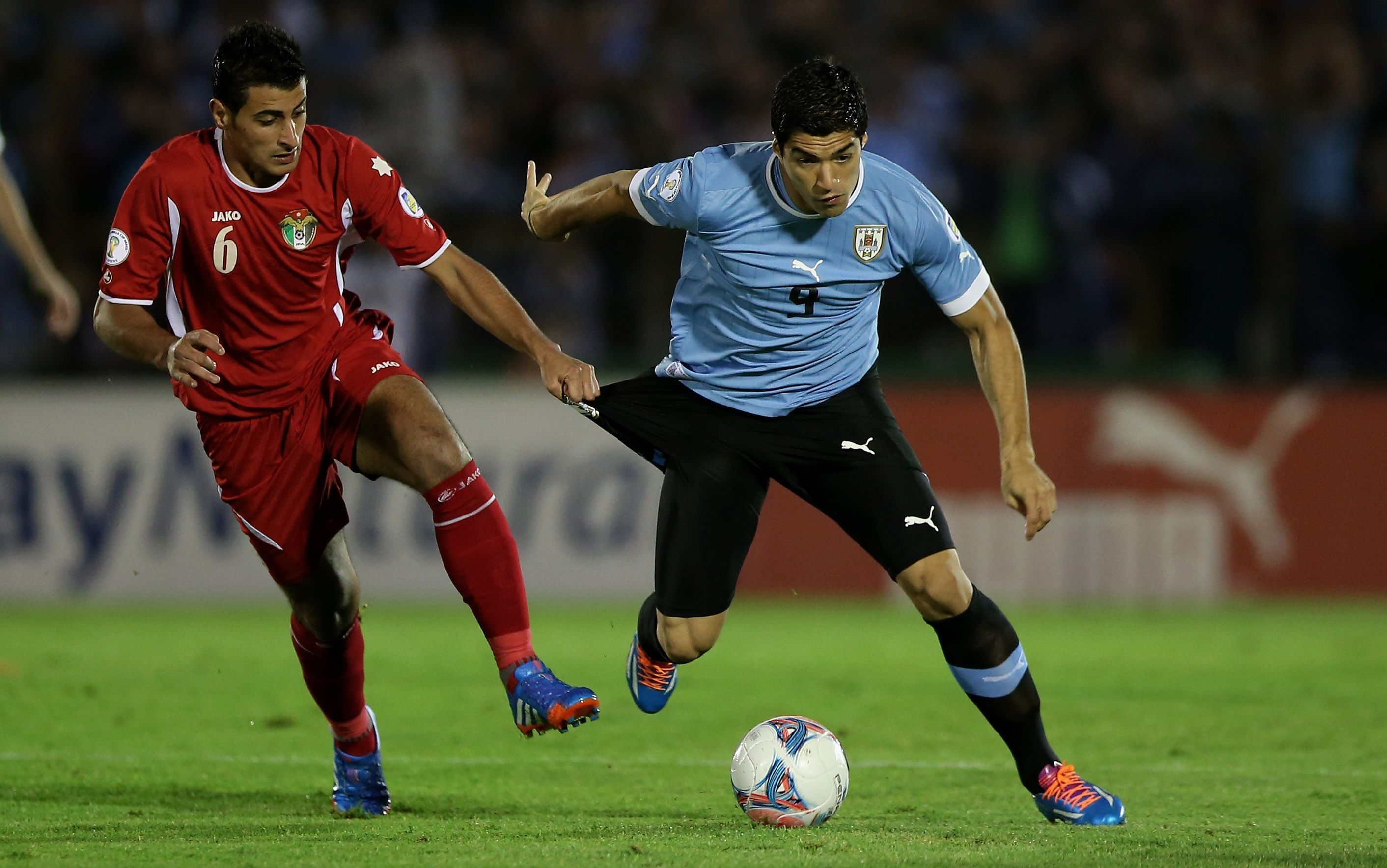 Luis Suárez, do Uruguai, disputa bola com adversário da Jordânia, na repescagem para Copa de 2014 • Friedemann Vogel/Getty Images