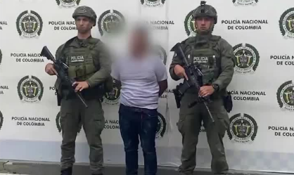Suposto responsável pelo ataque algemado ao lado de policiais colombianos