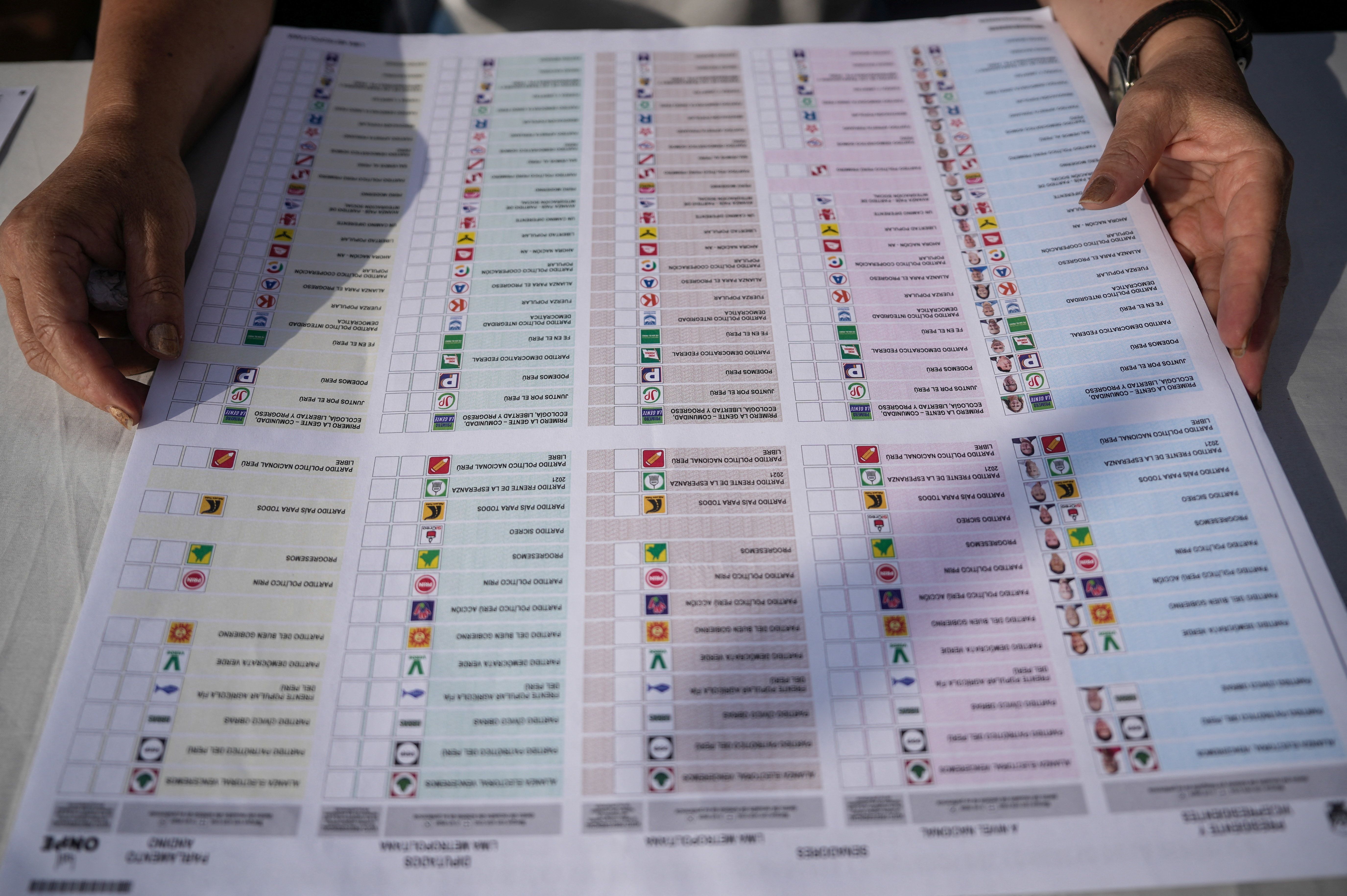 Um funcionário eleitoral manuseia cédula de votação no dia da eleição geral do Peru, em Lima